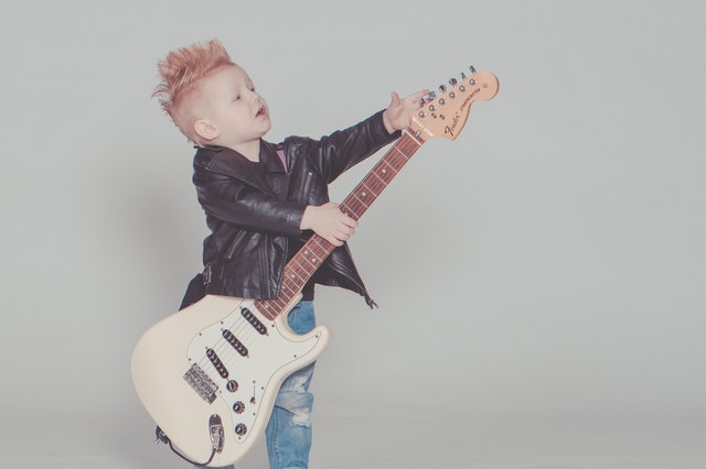 chlapeček hrající na elektrickou kytaru